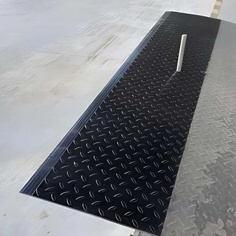 Edge-of-dock leveler installed at warehouse loading dock for bridging truck and platform height